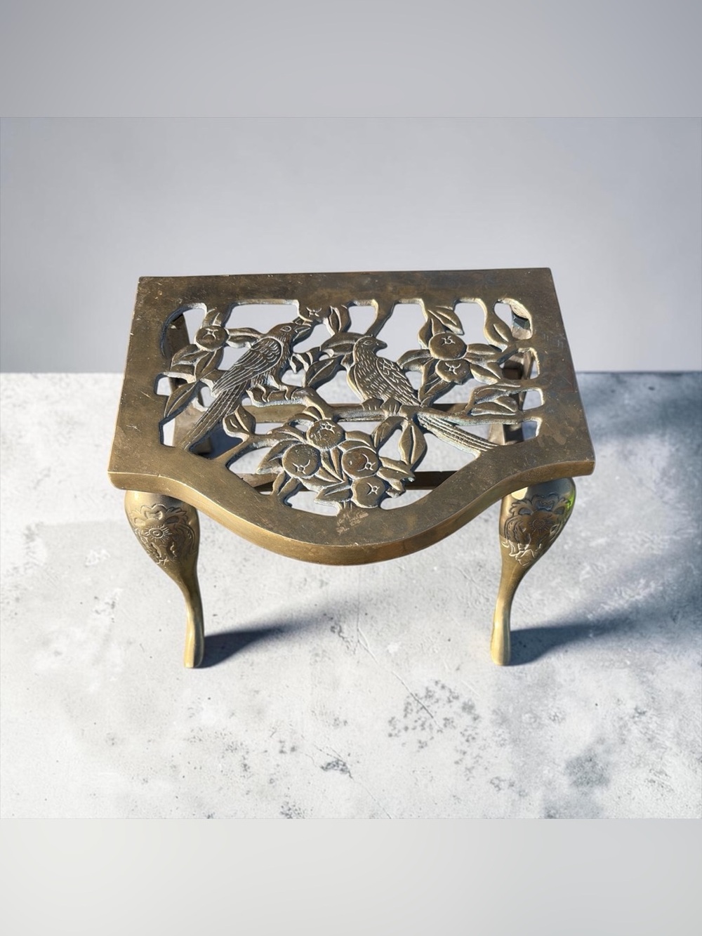 BRASS FIRESIDE TRIVET / KETTLE STAND FEATURING A PIERCED BIRD AND BERRY